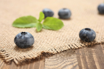 Obraz na płótnie Canvas fresh blueberries on a background of burlap and wooden