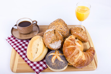 Viele Brötchen auf Brett mit Kaffee und Orangensaft