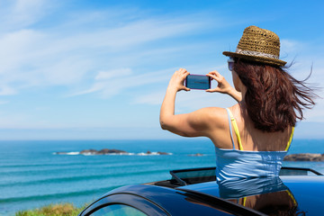 Woman taking photo with smartphone camera on summer travel