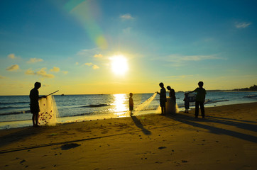 Fisherman silhouette with his family at sunset