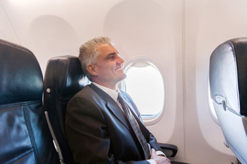 middle aged airplane passenger relaxing on air plane