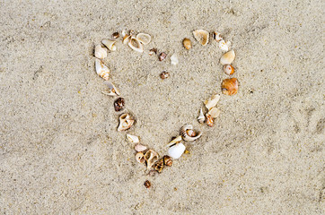 Fototapeta na wymiar heart from cockleshells on sand