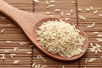 Brown rice in a wooden spoon