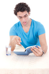 surprised man in blue t-shirt with glasses sitting at table and