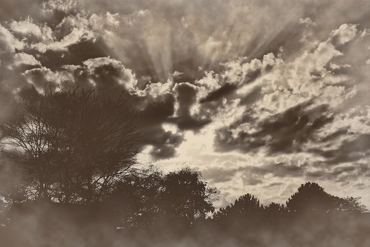 Dramatic sunset sunrise rays of light clouds sepia retro vintage