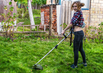 Woman in Plaid Shirt Mowing Lawn