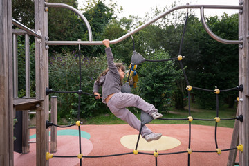 Young girl climbing in a playground outdoor.