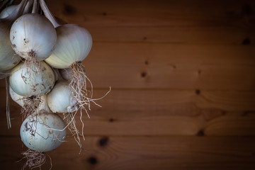 bunch white  of onions hanging on the wooden background