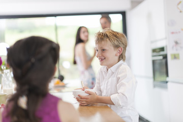 family in the kitchen at breakfast kid doing clown