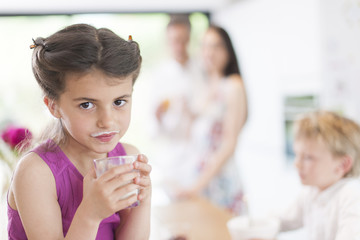 family in the kitchen at breakfast a little girl at foreground