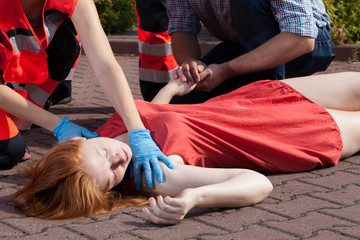 Paramedic helping unconscious woman