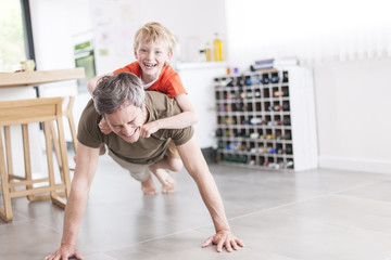 father and son  are doing pushups and having fun  at home