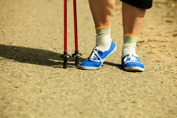 Plakat active woman senior nordic walking in park. legs