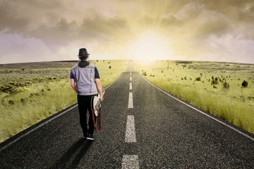 Fototapeta premium Lonely guitarist walking on road 1