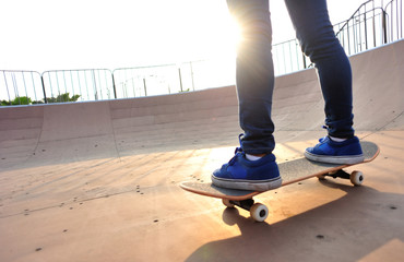 skateboarding woman legs at sunrise skatepark