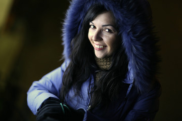 winter portrait of a brunette on a black background 