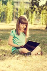 Obraz premium Little girl with laptop