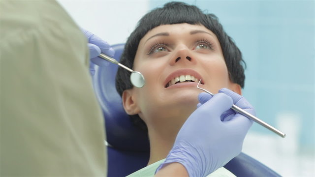 Dentist teeth carefully examines the patient girl