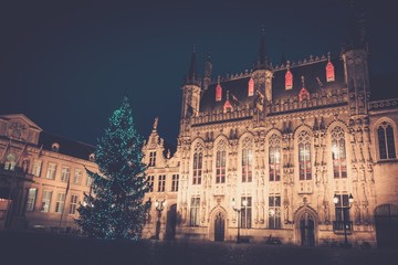 Fototapeta na wymiar Illuminated Christmas tree on a Burg square in Bruges, Belgium