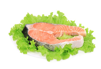 Raw salmon steak with lettuce salad.