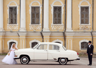 groom and bride in white vintage car