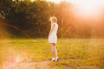 Obraz na płótnie Canvas Girl in the park in a white dress on a sunny day