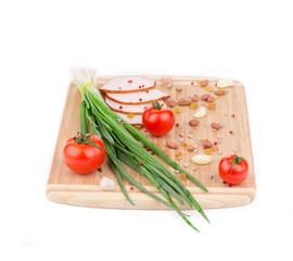 Fresh vegetables and ham on cutting board.