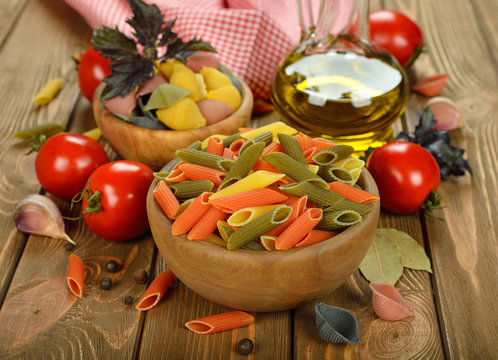 Uncooked pasta in wooden bowl