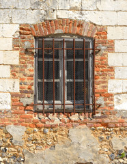 Fototapeta na wymiar fenêtre grillagee dans un mur délabré