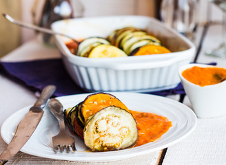 ratatouille sauce served in a round plate, fork, knife