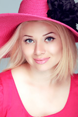 Beautiful blond woman in pink hat with makeup, smiling girl posi
