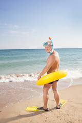 man in flippers and mask on the bank of the sea