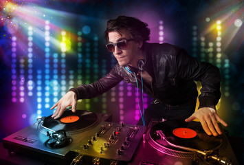 Dj playing songs in a disco with light show