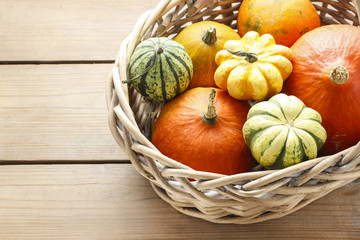 Basket of pumpkins on wooden table