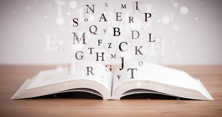 Opened book with flying letters