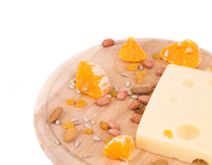 Cheese on board with nuts and orange.