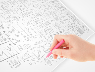Human hand sketching ideas on a white paper