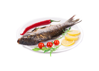 Grilled carp with vegetables on plate.