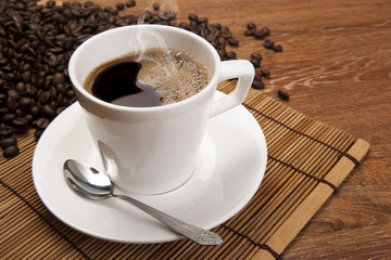 cup of black coffee with roasted coffe beans