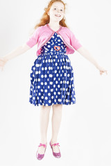 Happy Jumping Red-haired Caucasian Girl In Polka-Dotted Dress