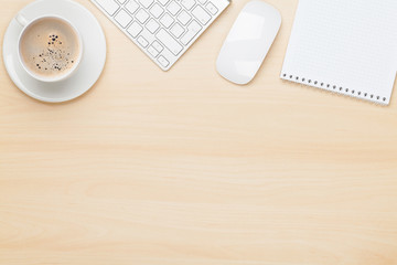 Office table with notepad, computer and coffee cup