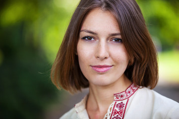 Fototapeta premium Closeup of young beautiful woman in summer park