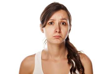 confused young woman posing on a white background
