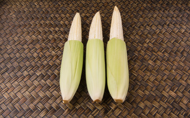 Baby corns over wicker background