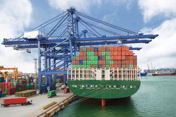 Container Ship in terminal working with shore crane at dock