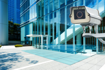 CCTV Camera or surveillance orperating with city building in bac