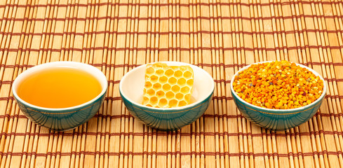 Honey, honeycomb and pollen in bowls