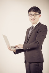 Asian business man using laptop computer isolated on white backg