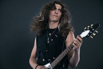 Obraz premium Male hard rock electric guitar musician with long hair. Studio s