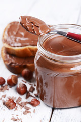 Sweet chocolate cream in jar on table close-up